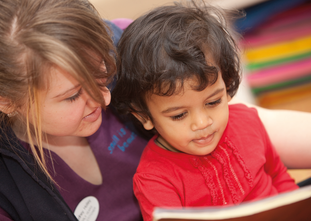 Carer reading to a child one on one
